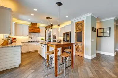 a kitchen with a wooden table and stools at California Vacation Rental with Private Pool and Patio in Visalia