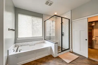 a bathroom with a tub and a shower and a window at California Vacation Rental with Private Pool and Patio in Visalia