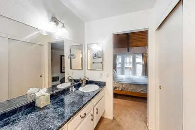 a bathroom with a sink and a mirror and a bed at St Moritz 9 in Mammoth Lakes