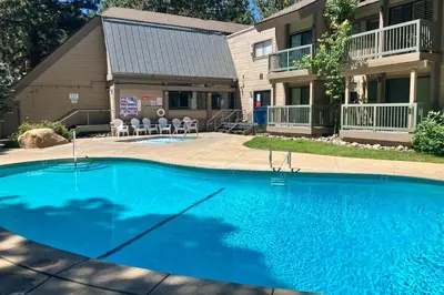 a large blue swimming pool in front of a house at St Moritz 9 in Mammoth Lakes