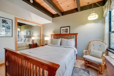 a bedroom with a large bed and a chair at Cozy Kings Beach Condo Near Lake Tahoe and Skiing in Kings Beach