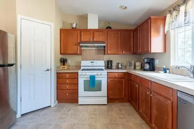 a kitchen with wooden cabinets and a white stove top oven at Mariposa Ridge Retreat in Mariposa