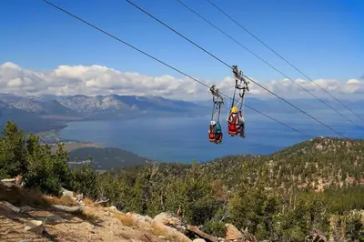 two people riding on a ski lift over a lake at Cozy 3BDR - 1 Minute to the Beach! in Tahoe Vista