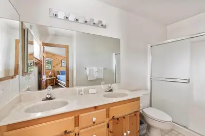 a bathroom with two sinks and a toilet and a mirror at Cozy 3BDR - 1 Minute to the Beach! in Tahoe Vista