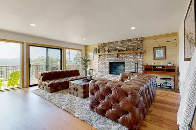 a living room with leather furniture and a fireplace at Walling Mountain Retreat in Groveland