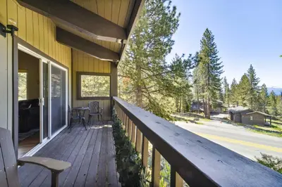 a deck with a table and chairs on a house at 10 Mi to Palisades Tahoe! Condo with Game Room in Tahoe City