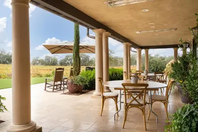 a patio with tables and chairs and an umbrella at Grand Reserve Inn in Plymouth