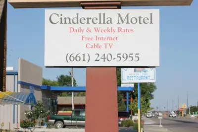 a sign in front of a building with a street at Cinderella Motel in Wasco
