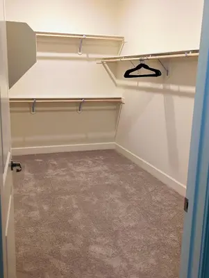 a walk in closet with shelves and carpet at Modern, Spacious & Relaxing Home in Sparks, NV in Sparks
