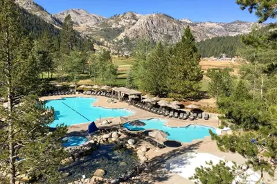 an aerial view of a resort pool with mountains in the background at Resort at Everline Resort & Spa #558 in Olympic Valley
