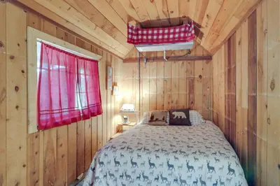 a bedroom with a bed in a wooden cabin at Dodge Ridge Pinecrest Mountain Cabin Near Hiking! in Cold Springs