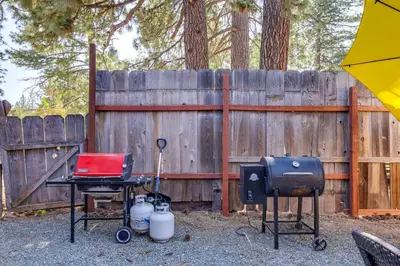 a backyard with a grill and a laptop on a table at Dodge Ridge Pinecrest Mountain Cabin Near Hiking! in Cold Springs