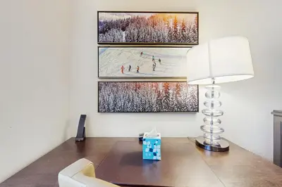 a desk with a lamp and two paintings on the wall at 556 Everline in Olympic Valley