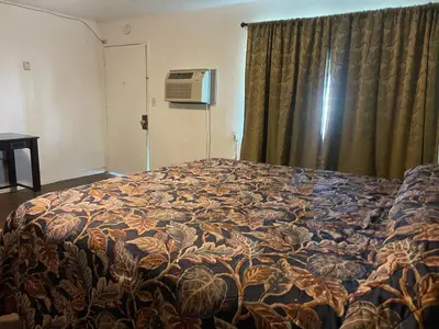 a large bed in a room with a window at Oak Motel Modesto CA in Modesto