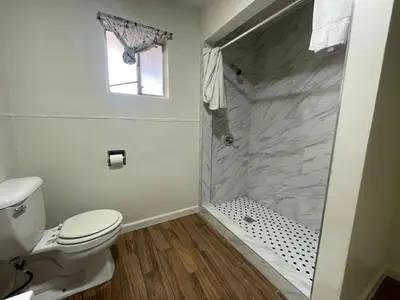 a bathroom with a toilet and a walk in shower at Oak Motel Modesto CA in Modesto
