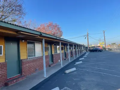 an empty parking lot next to a brick building at Oak Motel Modesto CA in Modesto