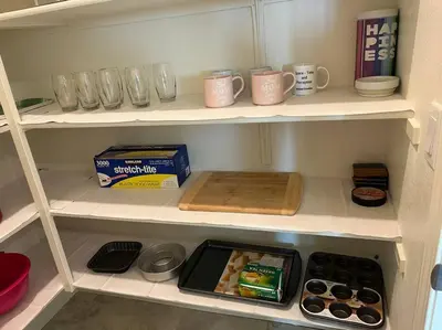 a cupboard filled with shelves filled with food and drinks at Brand-New, Beautiful & Stylish Home in Sacramento! in Sacramento