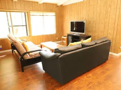 a living room with a couch and a tv at Green Cabin in Midpines in Midpines
