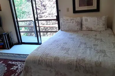 a large bed in a room with a large window at A Great Riverfront Retreat a Shangri-La Paradize in Valley Springs