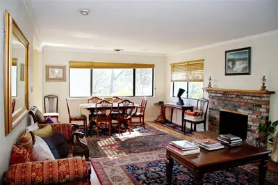 a living room with a fireplace and a table at A Great Riverfront Retreat a Shangri-La Paradize in Valley Springs