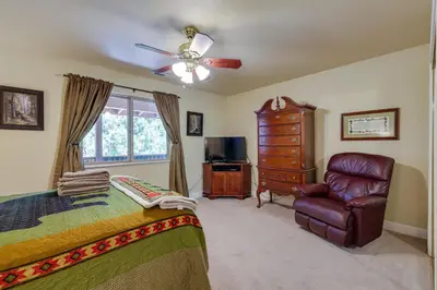 a bedroom with a bed and a chair and a ceiling fan at Groveland Vacation Rental Near Pine Mountain Lake! in Groveland