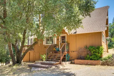 a person sitting on the stairs of a house at Groveland Vacation Rental about 26 Miles to Yosemite! in Groveland