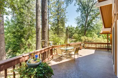 a deck with a table and chairs and trees at Groveland Vacation Rental about 26 Miles to Yosemite! in Groveland
