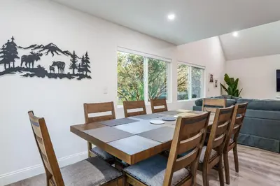 a dining room with a wooden table and chairs at A Modern Hideaway - with hot tub, game room, and more in Oakhurst