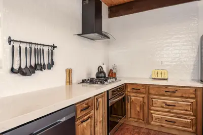 a kitchen with wooden cabinets and a counter top at Yosemite Sunrise House with hot tub/views/game room in Oakhurst