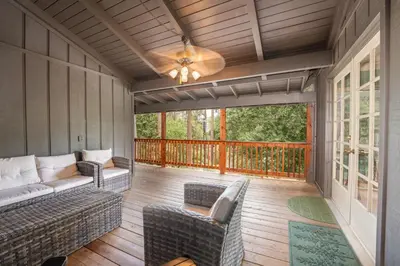 a screened in porch with a couch and chairs at Sierra Mountain Escape - Brand new spa/game room in Oakhurst