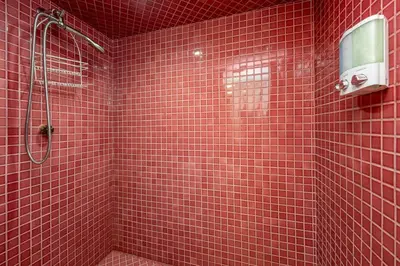 a red tiled bathroom with a shower with a window at Sierra Mountain Escape - Brand new spa/game room in Oakhurst