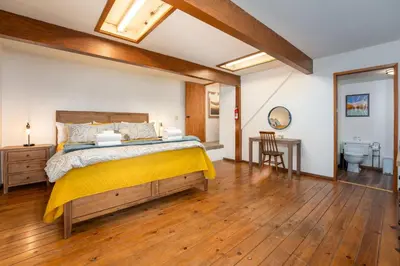 a bedroom with a large bed and a bathroom at Sierra Mountain Escape - Brand new spa/game room in Oakhurst