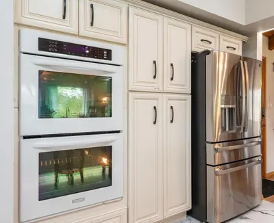 a kitchen with white cabinets and a refrigerator at Sunset Retreat- TWO houses with hot tub, firepit, multiple kitchens, sleeps 20 in Coarsegold