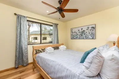 a bedroom with a bed and a ceiling fan at Sunset Retreat- TWO houses with hot tub, firepit, multiple kitchens, sleeps 20 in Coarsegold