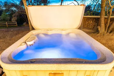 a hot tub in a chair in a yard at Sunset Retreat- TWO houses with hot tub, firepit, multiple kitchens, sleeps 20 in Coarsegold