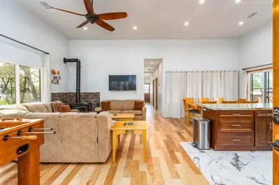 a living room with a couch and a table at Sunset Retreat- TWO houses with hot tub, firepit, multiple kitchens, sleeps 20 in Coarsegold