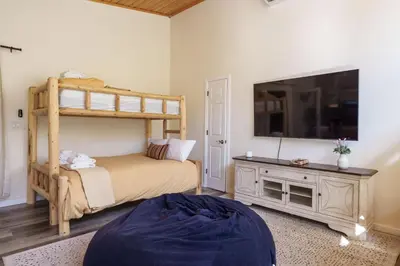 a bedroom with a bunk bed and a tv at Yosemite Creekside Retreat with spa/games/EV Charger and more in Oakhurst