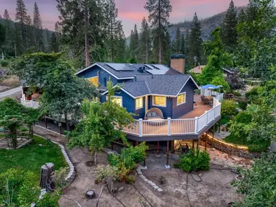 an aerial view of a blue house in the woods at Yosemite Creekside Retreat with spa/games/EV Charger and more in Oakhurst