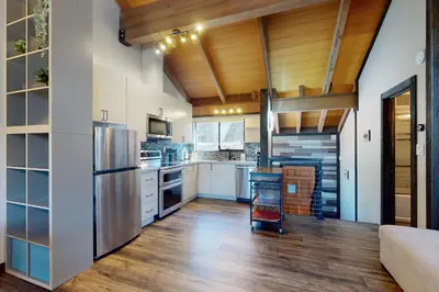 a kitchen with white cabinets and a wooden ceiling at Rocky Point Paradise in Truckee