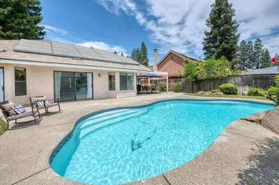 a swimming pool in the backyard of a house at Stylish 3BR/2BA Retreat w/ Pool! Dream Getaway in Fresno