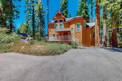 a large orange house in the middle of a forest at Granite Tranquility in Yosemite West