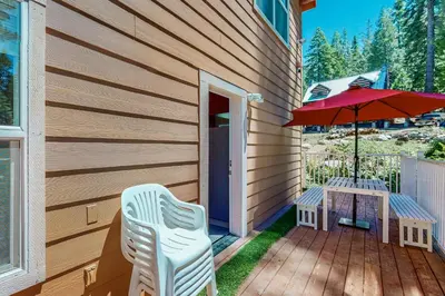 a patio with a table and a red umbrella at Granite Tranquility in Yosemite West