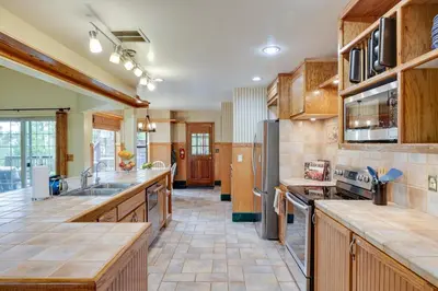 a large kitchen with wooden cabinets and appliances at Mi-Wuk Village Vacation Rental with Multi-Level Deck in Mi-Wuk Village