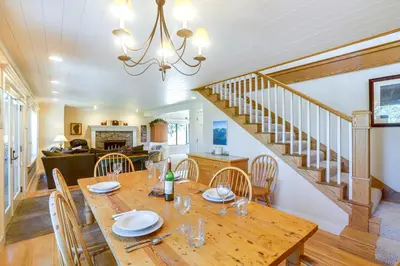 a dining room with a wooden table and a staircase at 2 Mi to Lake Tahoe Spacious and Serene Retreat! in Tahoe City