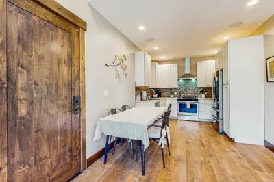 a kitchen with a table and chairs and a large wooden door at Red Mountain Lodge in Truckee