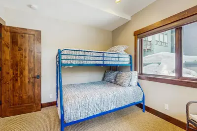 a blue bunk bed in a room with a window at Red Mountain Lodge in Truckee