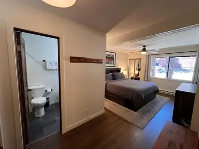 a bedroom with a bed and a toilet and a mirror at Cozy Ski Condo - Walk to Canyon - Dog Friendly in Mammoth Lakes