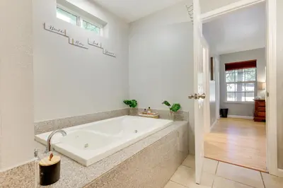 a white bath tub in a bathroom with a window at Near Dtwn Twain Harte Home with Furnished Deck! in Twain Harte