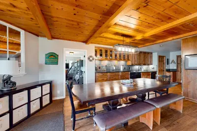 a kitchen with a wooden table and a dining room at Bass Lake Lodge in Bass Lake
