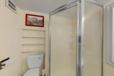 a bathroom with a toilet and a glass shower at Bass Lake Lodge in Bass Lake